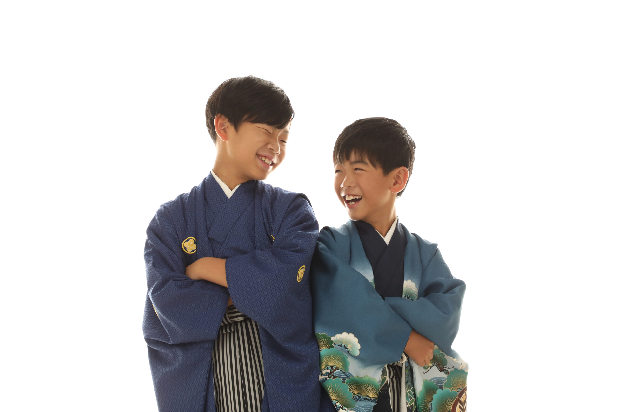 紺と青緑の羽織袴で肩を並べて笑い合う男の子ふたり