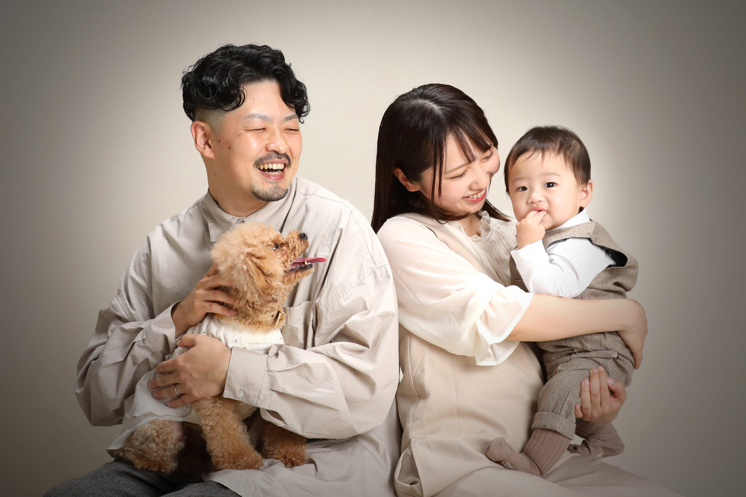 トイプードルを抱くお父様と1歳の男の子を抱くお母様のご家族