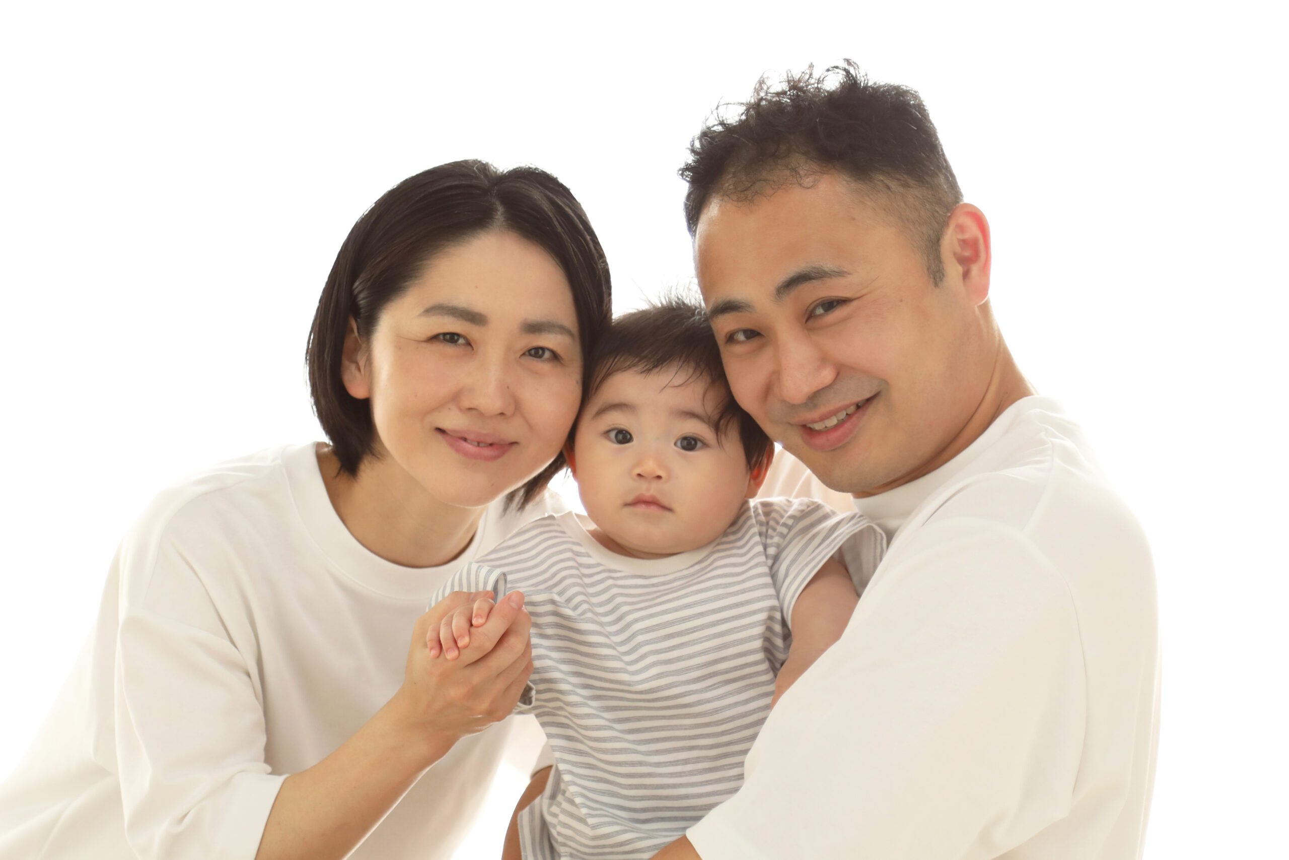 白いTシャツで頬を寄せ合いカメラを見つめるご両親と赤ちゃん